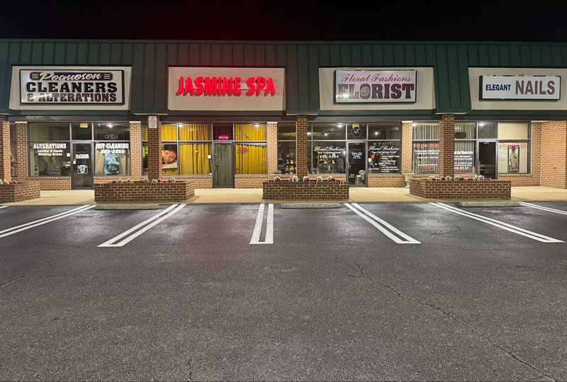 Bright white parking space lines freshly painted on black asphalt
